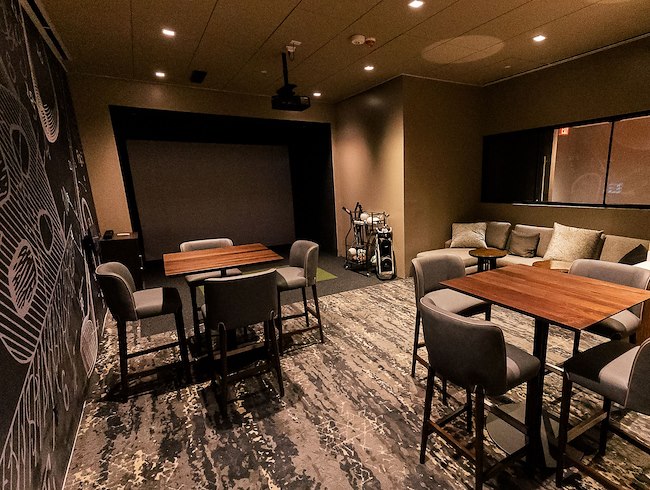 Private Topgolf Swing Suite with simulator, seating, and dining table.